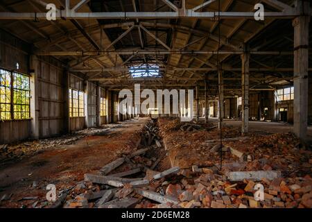 Abandoned ruined large industrial hall with garbage waiting for demolition Stock Photo