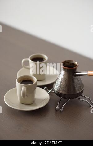 Two cups of Traditional Turkish coffee brewed in coffee pot minimalist style vertical Stock Photo