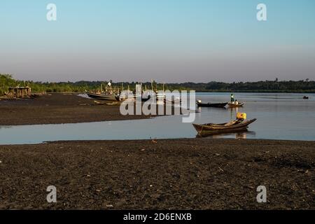 Chaung Thar, Myanmar - December 26, 2019: People in traditional wooden fishing boats by the coast during sunset on December 26, 2019 in Chaung Thar Stock Photo