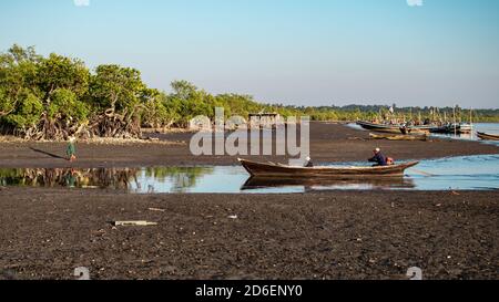 Chaung Thar, Myanmar - December 26, 2019: People in traditional wooden fishing boats by the coast during sunset on December 26, 2019 in Chaung Thar Stock Photo