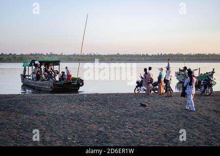 Chaung Thar, Myanmar - December 26, 2019: The local ferry arrives as people waits on the shore on December 26, 2019 in Chaung Thar, Myanmar Stock Photo