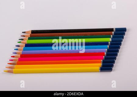Stacked colored pencils on a light background. Side view. Stock Photo