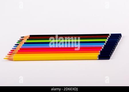 Stacked colored pencils on a light background. Side view. Stock Photo