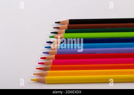 Stacked colored pencils on a light background. Side view. Stock Photo