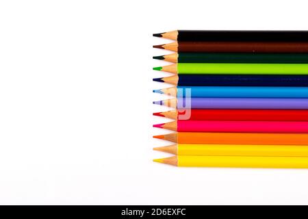 Stacked colored pencils on a light background. Side view. Stock Photo