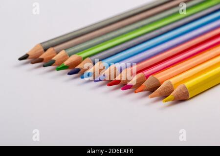 Stacked colored pencils on a light background. Side view. Stock Photo