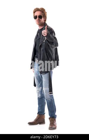 Confident handsome redhead man with sunglasses in leather jacket showing thumbs up like gesture. Full body isolated on white background. Stock Photo