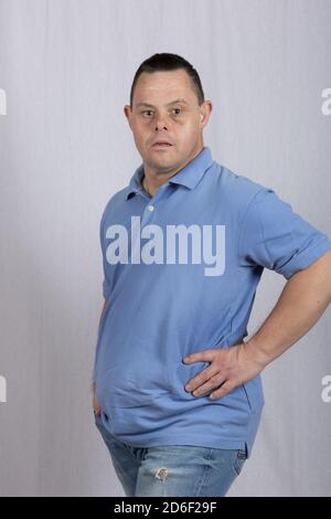 Happy man with Down syndrome in a white background photo studio wearing jeans Stock Photo