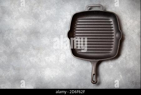 Black iron empty grill pan on gray concrette background. top view. Stock Photo