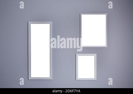 Poster mockup with three frames on empty grey wall  Stock Photo