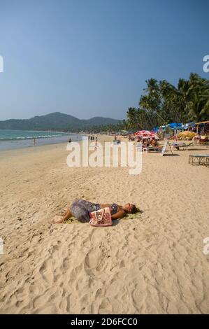 Sunbathing on a beach in Goa Stock Photo