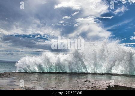 Dramatic dfisplay od the explosiveness of nature seen by a huge wave breaking against the pier at Olawalu Landing on Maui. Stock Photo