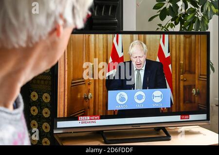 Prime Minister Boris Johnson giving a press conference from Downing Street in regard to Covid-19 with 'Hands, face space' logo advice.