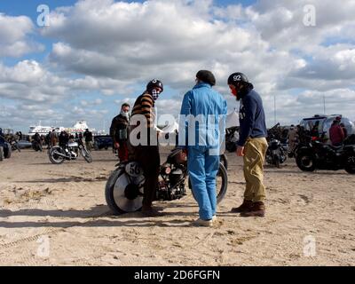 Normandy Beach Race on the Ouistreham beach, old Harley Davidson motorcycle breakdown and riders helping each other, old retro clothing