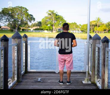 young man flying a drone i the park in a sunset Stock Photo