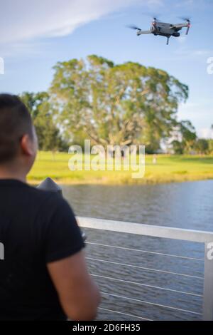 young man flying a drone in the park in a sunset Stock Photo