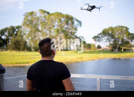 young man flying a drone in the park in a sunset Stock Photo