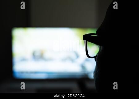 Man Using Magnifying Glasses for Watching TV Stock Photo
