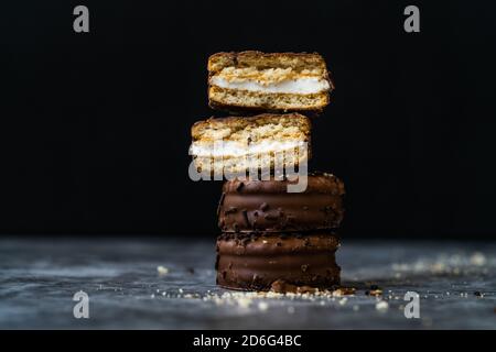 Traditional Alfajores (Alfajor) with dulce de leche covered with chocolate - Traditional Argentine sweet. Ready to Eat. Stock Photo