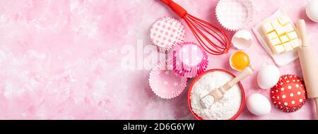 Baking background. Food ingredients for baking flour, eggs, sugar on pink background flat lay. Baking or cooking cakes or muffins. Long format with co Stock Photo