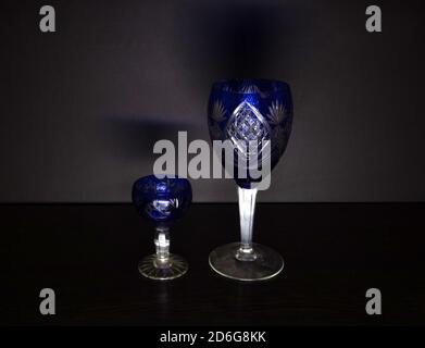 Two vintage wine goblets of blue glass against minimalist dark background Stock Photo
