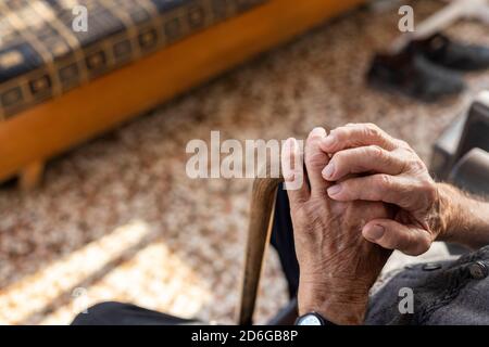 Close up of elder man's hands on a cane. Selective focus Stock Photo