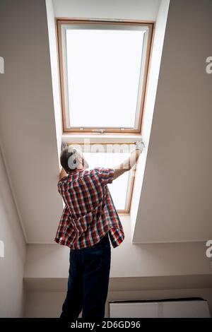 Back view of worker leaning measuring tape on window Stock Photo
