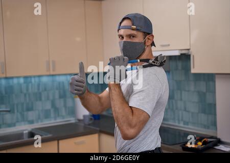 Young caucasian service man in mask showing thumb up Stock Photo