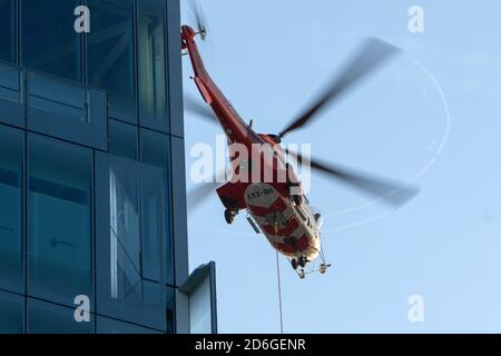 Birmingham, United Kingdom, 17th October 2020. Unusual Saturday morning sight in Birmingham city centre as Super Puma Helicopter conducted load lifts from between the high rise office blocks in Snow Hill Queensway. HeliRig organised the operations utilising a Swiss based Aerospatiale AS332C Super Puma based out of Wolverhampton Halfpenny Green Airport for the duration of the operation which included facilitating a vertical take off trailing an 80m lifting cable. Super Puma operating between the high rise offices in Birmingham Credit:Paul Bunch/Alamy Live News. Stock Photo