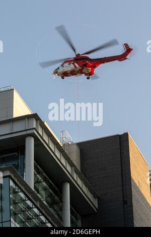 Birmingham, United Kingdom, 17th October 2020. Unusual Saturday morning sight in Birmingham city centre as Super Puma Helicopter conducted load lifts from between the high rise office blocks in Snow Hill Queensway. HeliRig organised the operations utilising a Swiss based Aerospatiale AS332C Super Puma based out of Wolverhampton Halfpenny Green Airport for the duration of the operation which included facilitating a vertical take off trailing an 80m lifting cable. Super Puma operating between the high rise offices in Birmingham Credit:Paul Bunch/Alamy Live News. Stock Photo