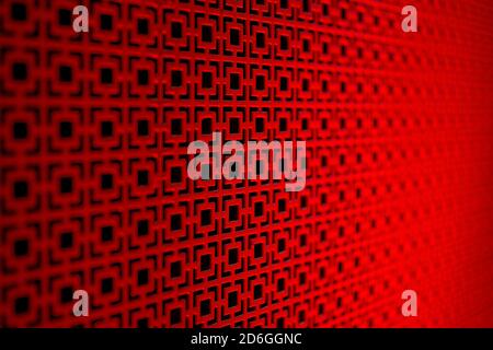 Grid forming geometric red patterns on black with selective focus and blurred background Stock Photo