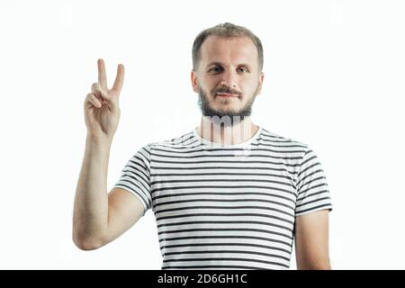handsome young bearded man showing victory fingers sign. isolated on white background. Stock Photo