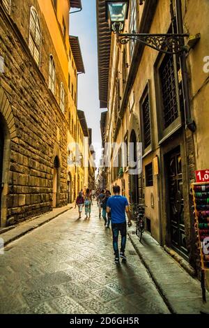 Portrait shot of a narrow alley in the historic city centre of Florence, Tuscany, Italy on a sunny day in autumn. Stock Photo