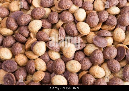 Decorative food texture from heap of nutty sweets in half walnut shape. Two-color culinary background of yummy baked Xmas shortcrust cookies. Top view. Stock Photo