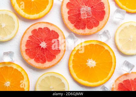 slices of grapefruit orange and lemon with ice on a white background Stock Photo