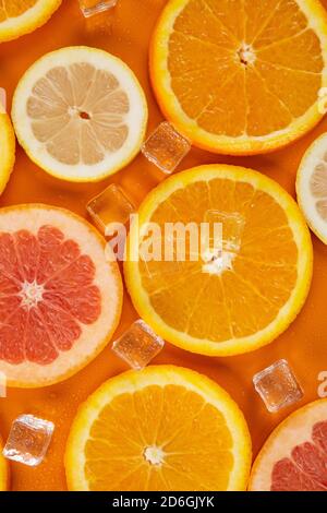slices of grapefruit orange and lemon on a orange background Stock Photo