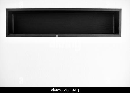 Black shelf integrated in a white wall Stock Photo