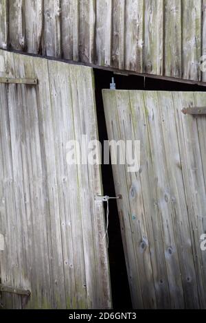 Wooden doors on a wonky old timber barn Stock Photo