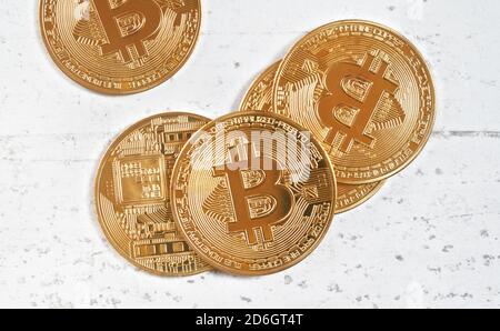 Top down view, golden commemorative btc - bitcoin cryptocurrency - coins scattered on white stone board, closeup detail Stock Photo