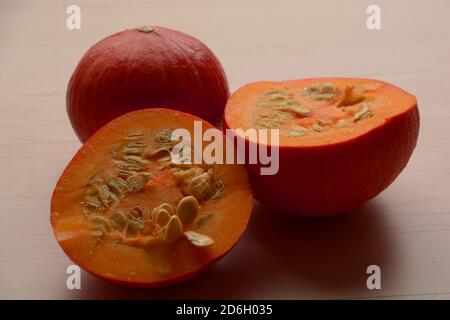 red kuri squash pumpkins with a halved one studio shot Stock Photo