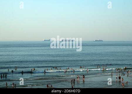 The big ocean liners are anchored by the coast of the dutch city of Hague and are visible on the horizon. The ships are not used because of the corona Stock Photo