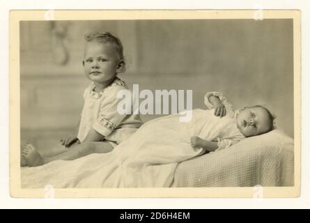 Studio portrait postcard of baby in christening gown and toddler, circa 1940's, U.K Stock Photo