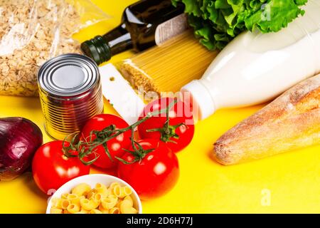 Various healthy food, tomato, bread, pasta ,olive oil and vegetables on yellow background. Food delivery and donation concept. Stock Photo