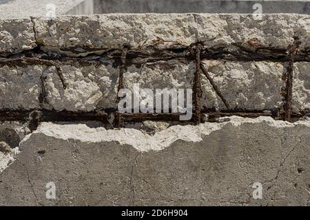 Concrete wall with rusty rebar in it, which can cause concrete to rot. This wall cannot besaved. Stock Photo