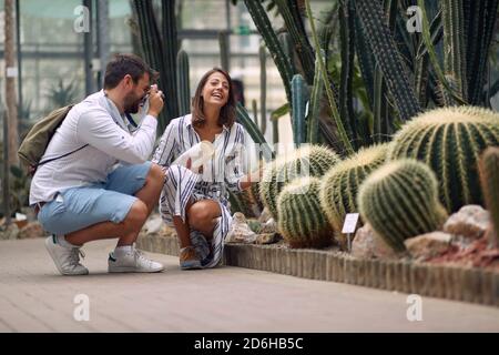 Male visitor taking photo of a beautiful female guide at the botanical garden Stock Photo
