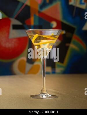 Vodka Martini cocktail with lemon twist on golden cloth in front of Kandinsky artwork Stock Photo
