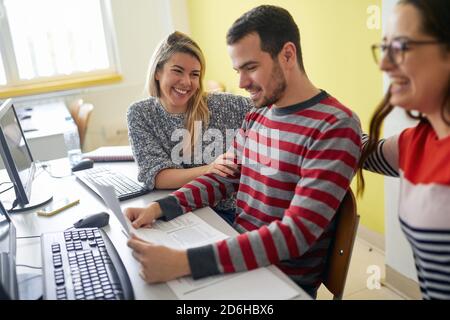 Students having a good time in the break of an informatics lecture in the university computer classroom. Smart young people study at the college. Educ Stock Photo