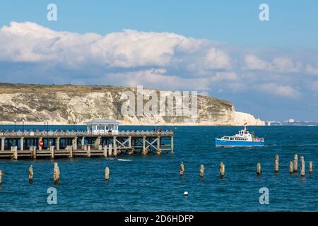 Dorset UK. 17th October 2020. UK weather: Sunny on the Dorset coast, as people make the most of the Autumnal sunshine. The Dorset Belle boat approaches Swanage Pier with the remains of the old pier in the foreground. Credit: Carolyn Jenkins/Alamy Live News Stock Photo
