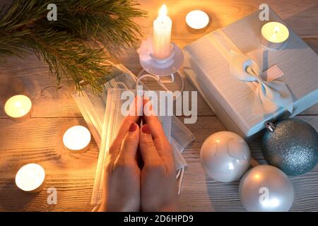 Medical masks on the Christmas table with a gift box. Stock Photo
