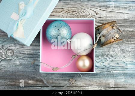 Gift box with Christmas balls on a wooden background. The view from the top. Stock Photo